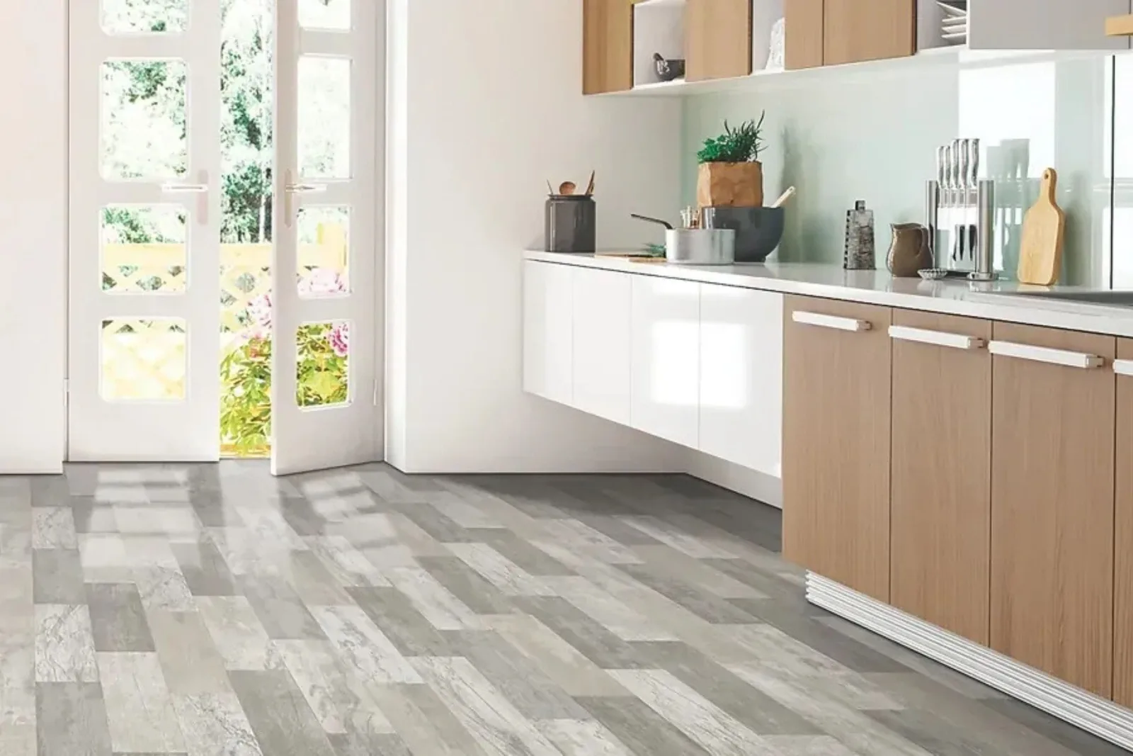 Modern kitchen with durable gray wood-look vinyl plank flooring in a random pattern, a stylish and water-resistant alternative for high-traffic areas.