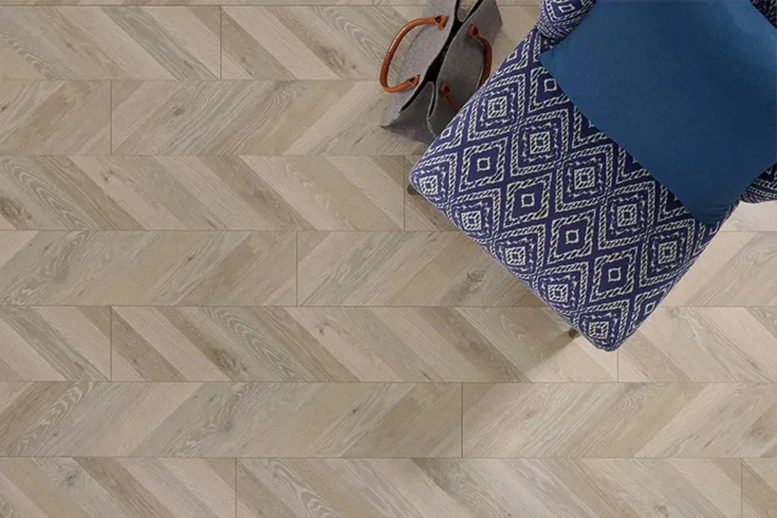 Overhead view of durable light wood-look vinyl plank flooring in a stylish herringbone pattern, a water-resistant and easy-to-clean alternative to hardwood.