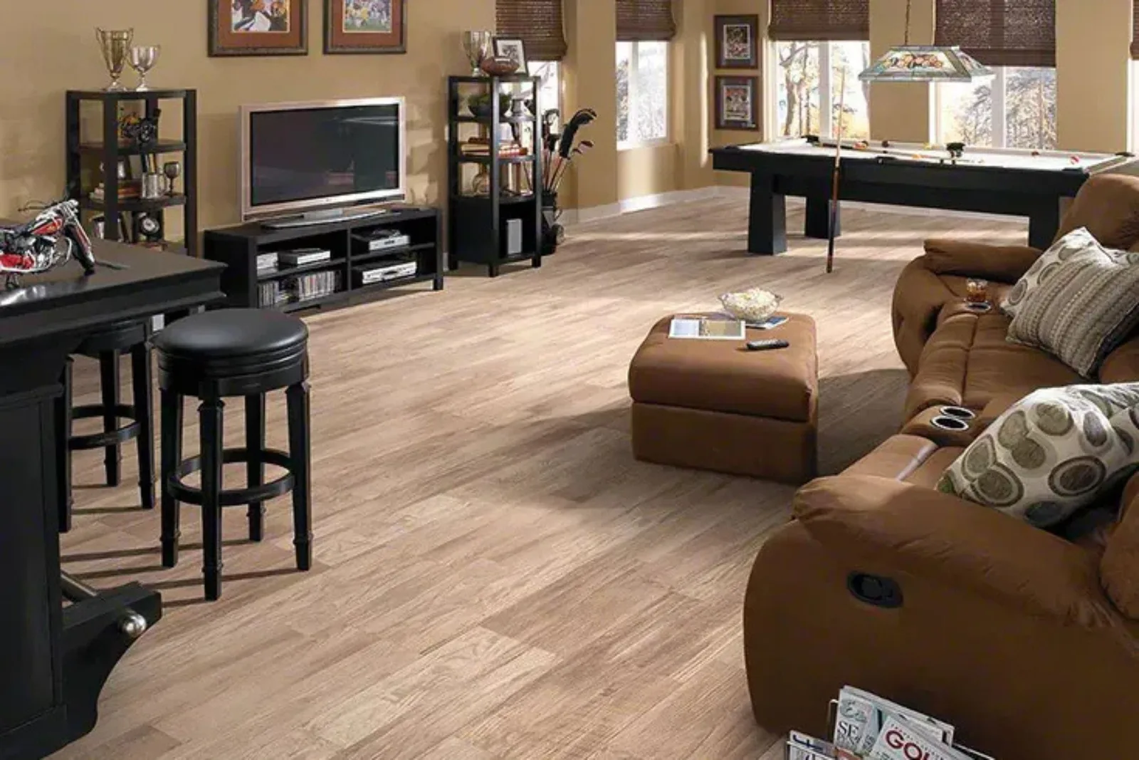 Entertainment room with durable medium wood-look vinyl plank flooring and a pool table, a water-resistant and easy-to-clean alternative to hardwood.