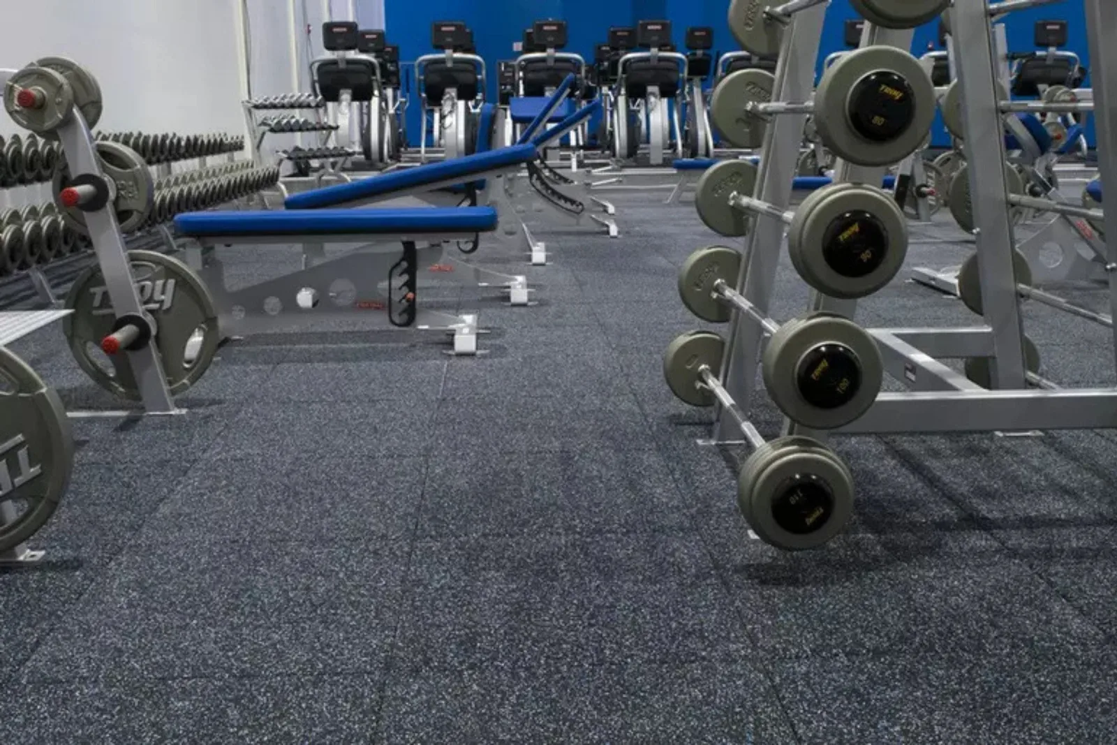 Commercial gym with durable gray speckled interlocking gym floor tiles, a high-quality and protective flooring solution for weight rooms and fitness centers.