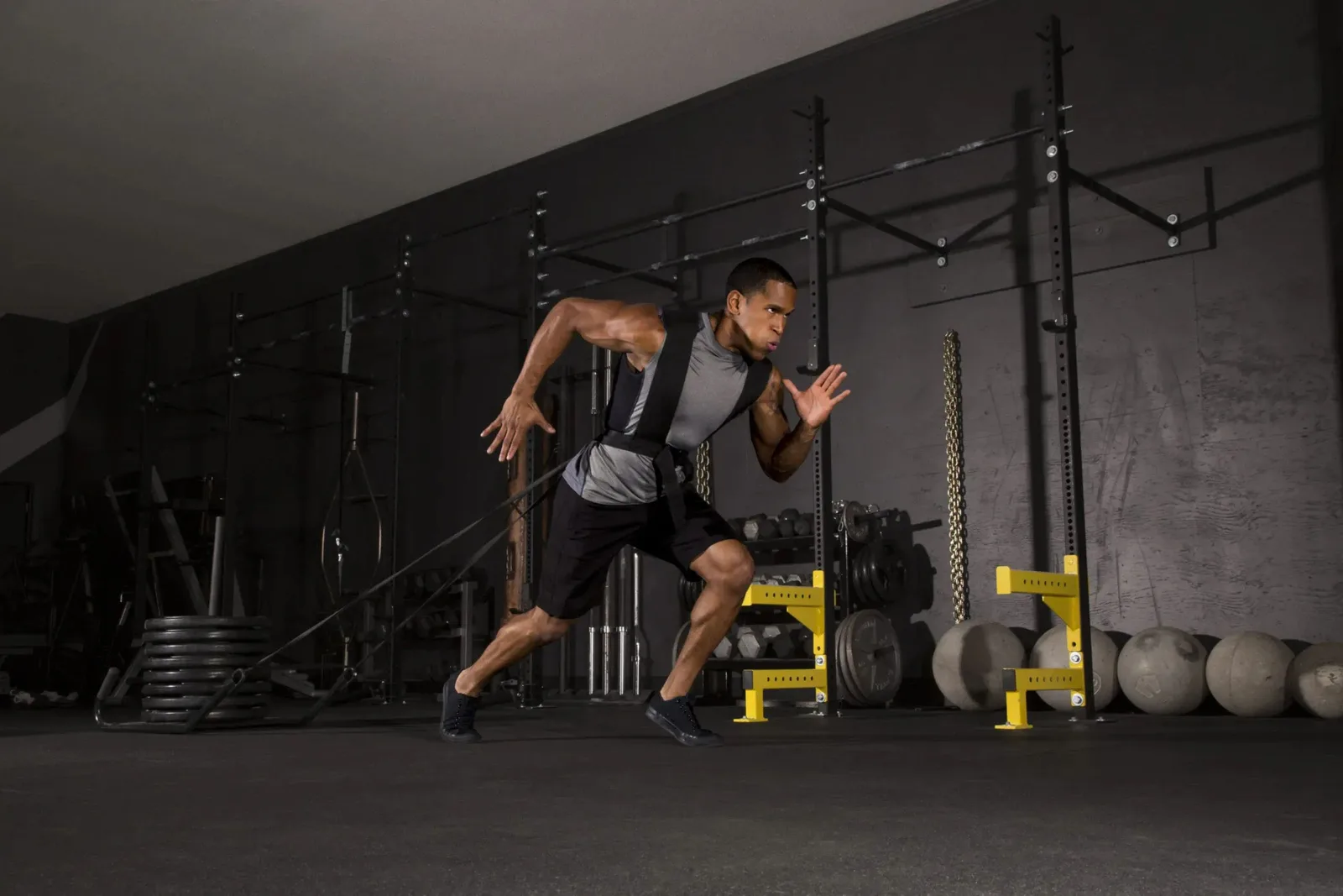Person sprinting in a gym on durable black rubber gym flooring, a high-performance and shock-absorbing flooring solution for a workout space.