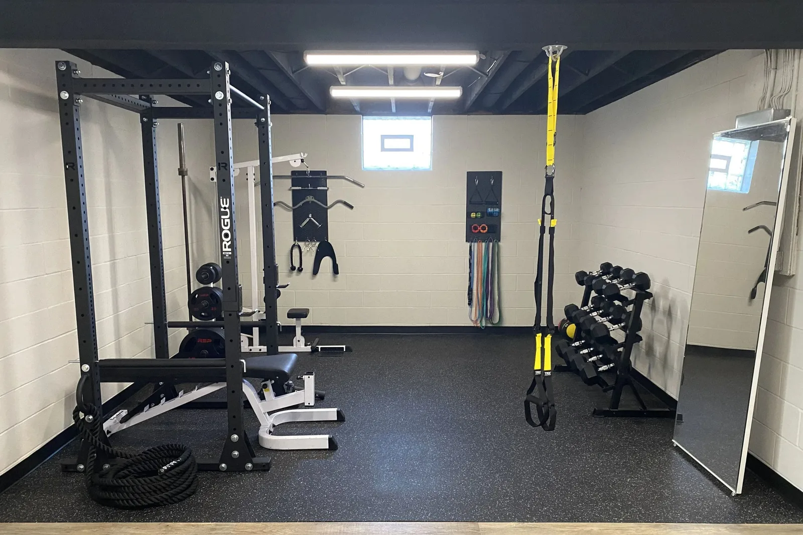 Home gym with durable black speckled rubber interlocking gym floor tiles, a high-quality and protective flooring solution for residential workout spaces.