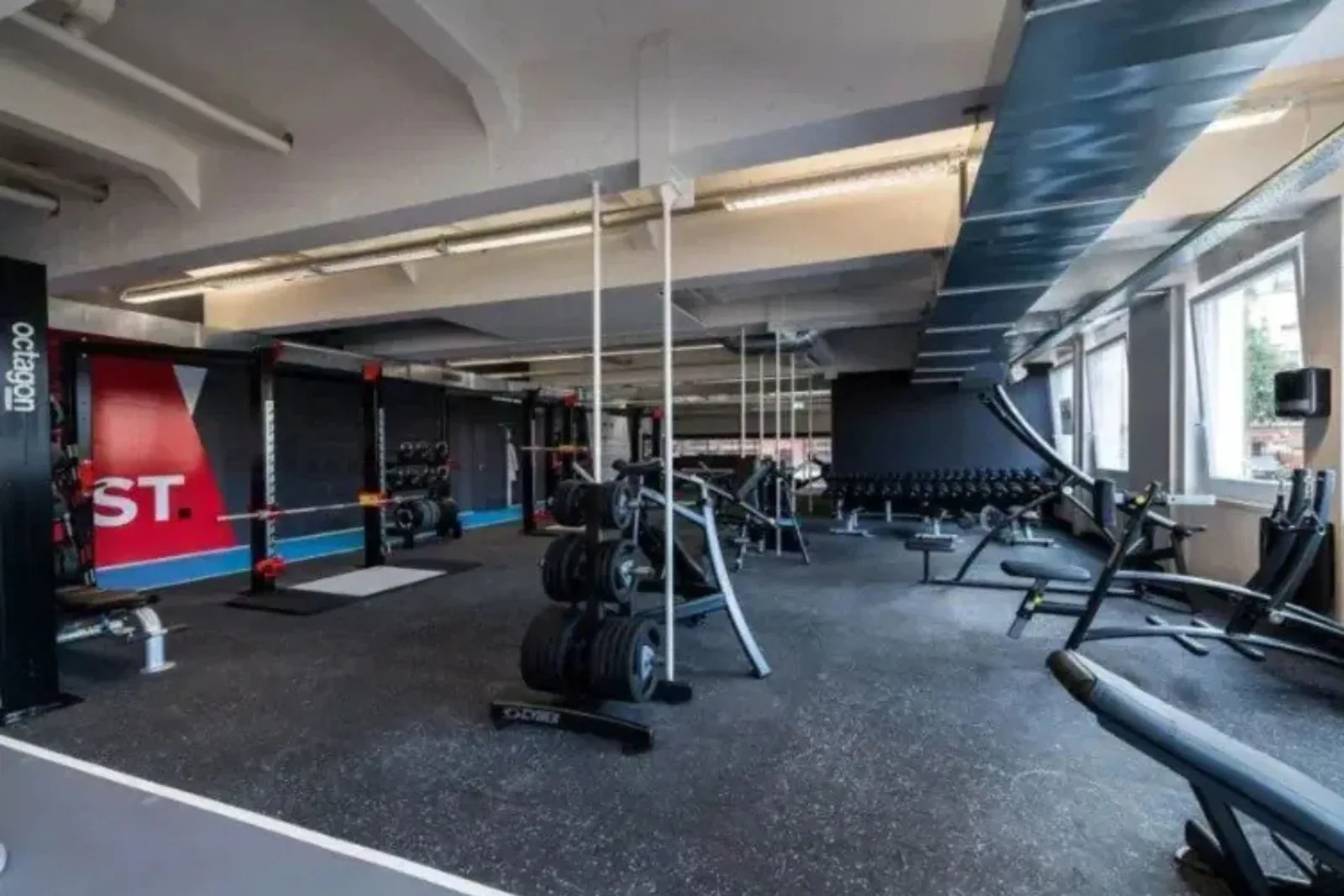 Commercial gym with durable black speckled rubber gym flooring, a high-performance and protective solution for a weight room and fitness center.