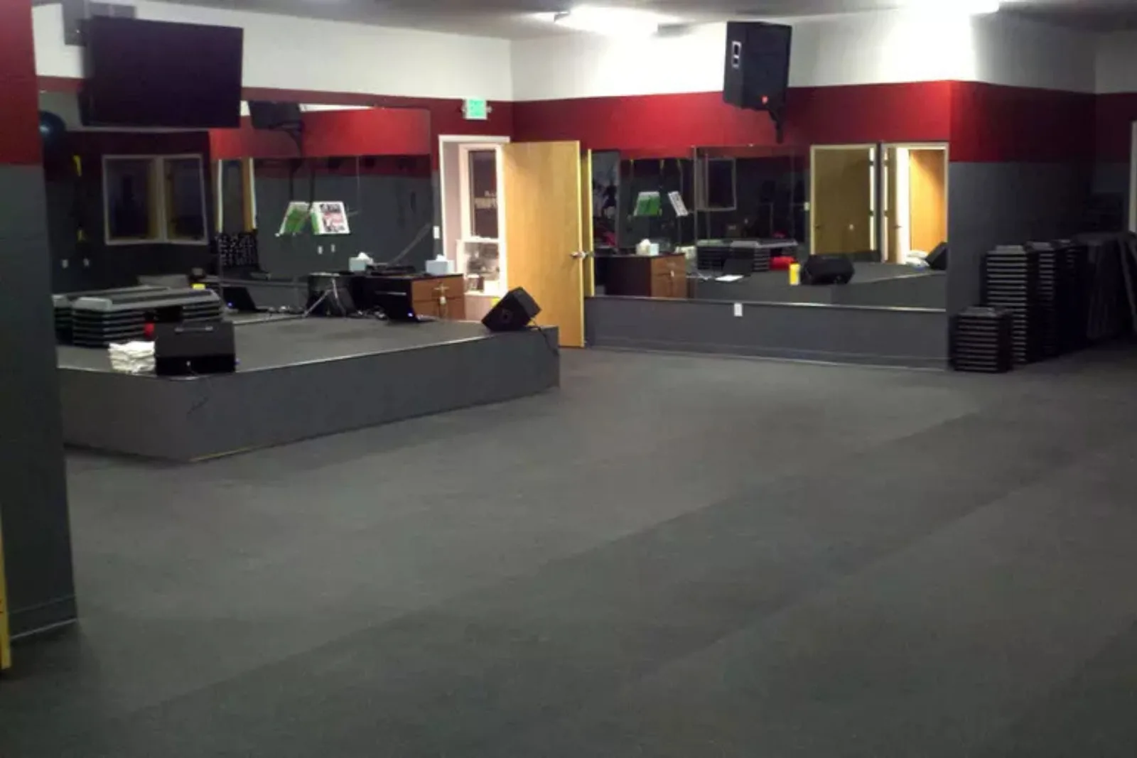 Commercial fitness studio with durable black rubber interlocking gym floor tiles, a high-performance and protective flooring solution for high-traffic environments.