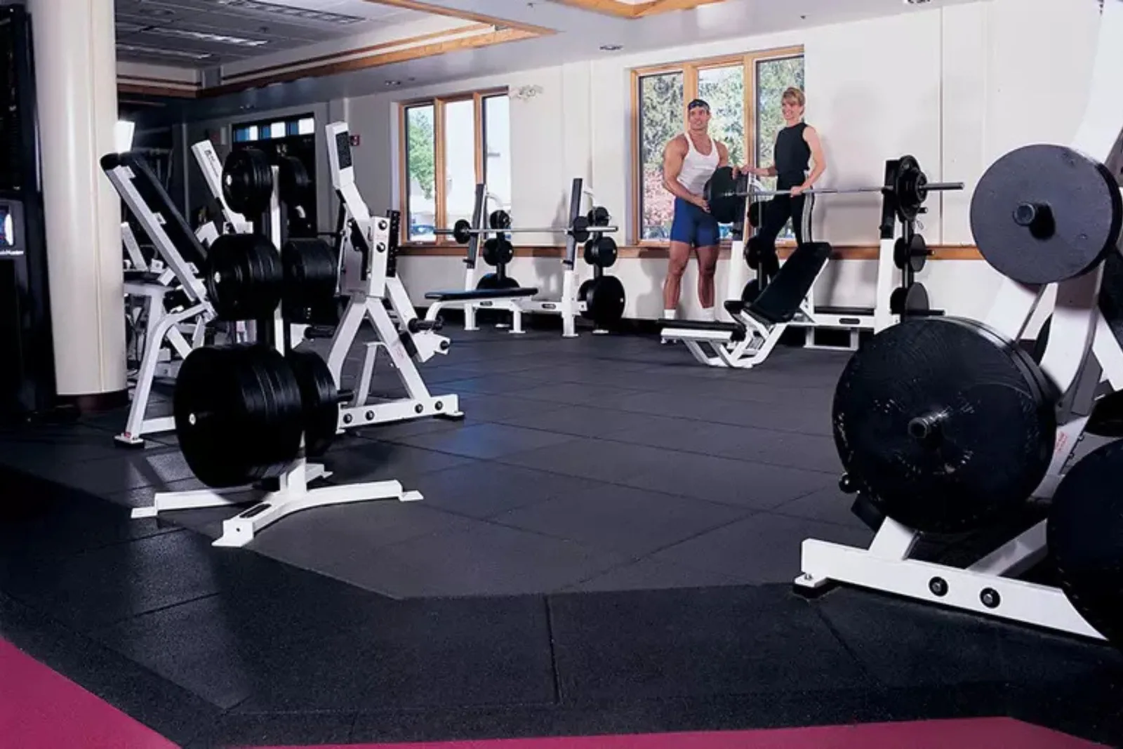 Commercial gym with durable black rubber interlocking gym floor tiles, a high-quality and protective flooring solution for weight rooms and fitness centers.