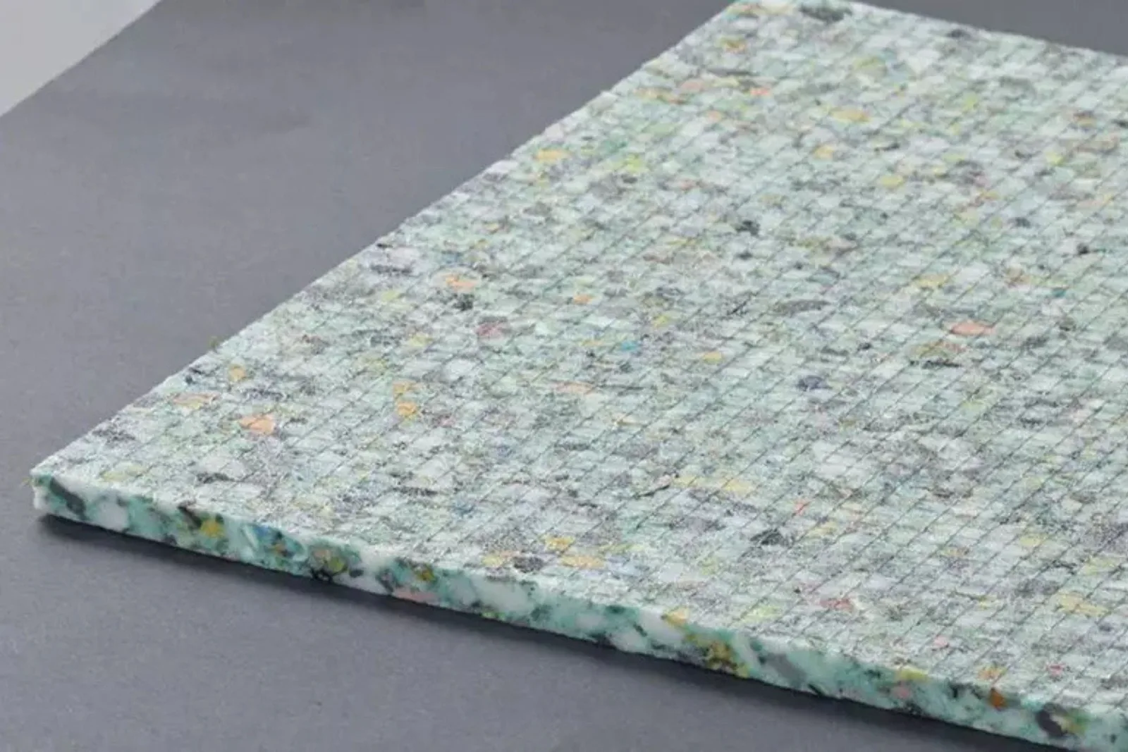 Close-up of a durable multi-colored foam underlayment, a high-quality product that provides padding and sound absorption for various flooring types.