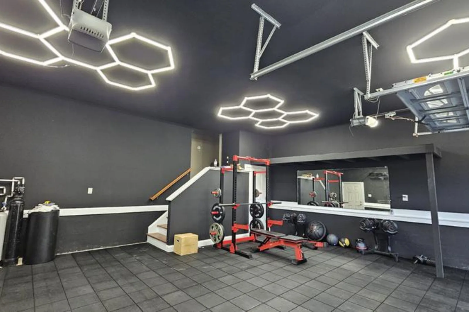 Black rubber interlocking gym mats in a home gym converted from a garage
