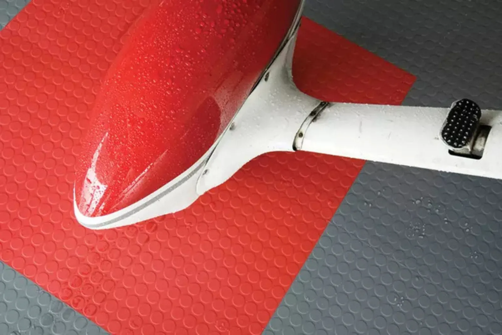 Waterproof garage floor mats in red and grey, ideal for protecting floors from spills under a vehicle or plane