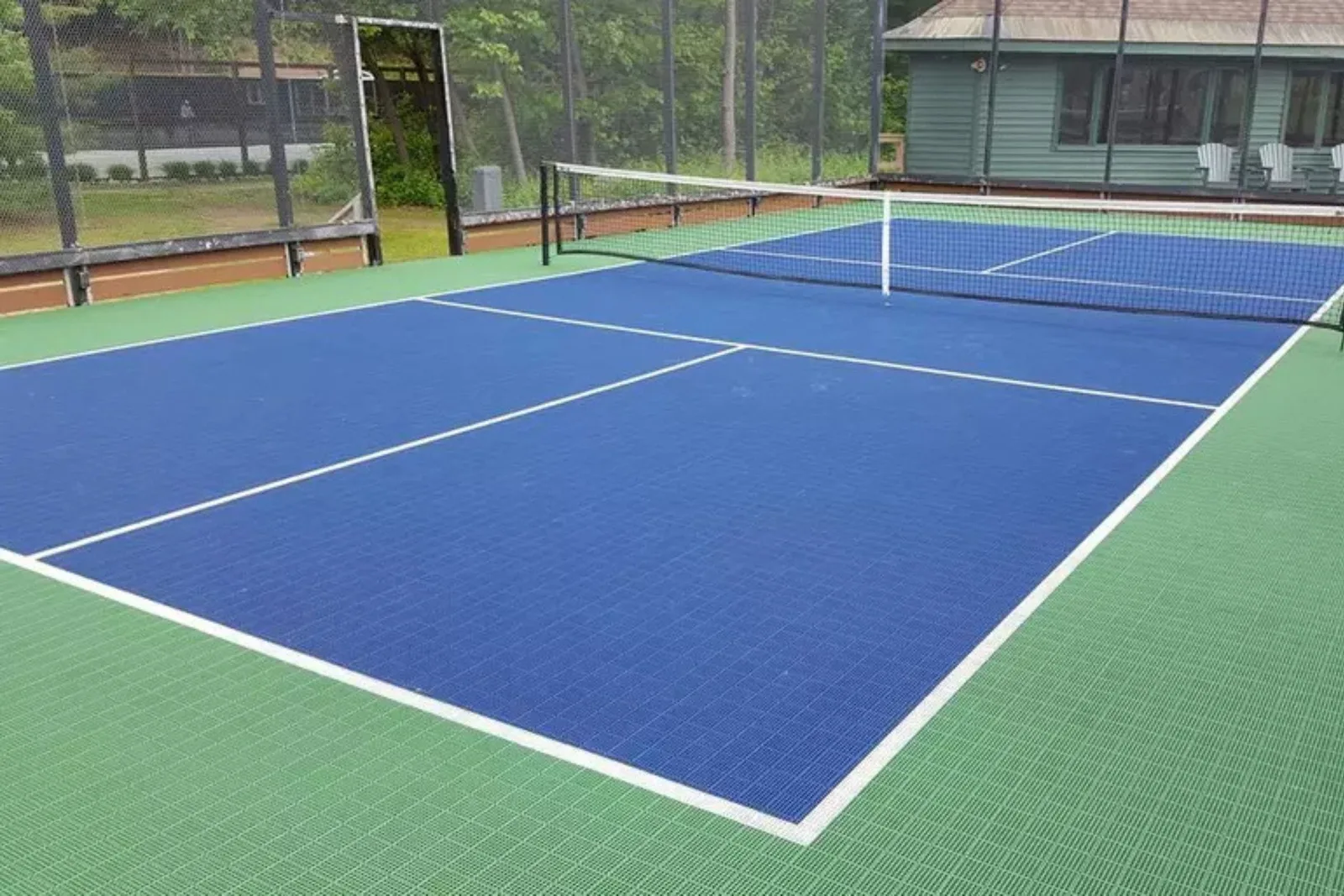 Interlocking all-weather PVC tennis court tiles in blue and green, providing a durable and professional playing surface for outdoor use.
