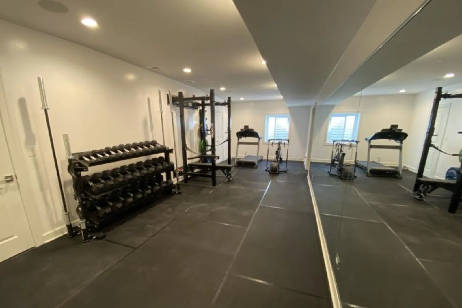 Home gym with durable black rubber interlocking gym floor tiles, a high-performance and protective flooring solution for residential workout spaces.