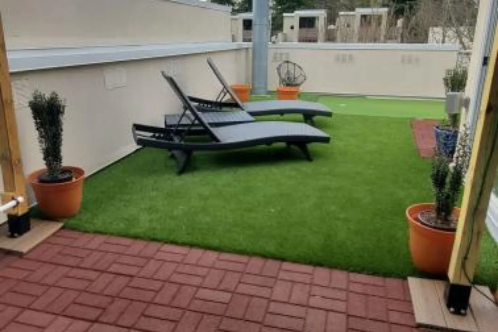 Flagstone rubber pavers and artificial grass create a unique, low-maintenance, and stylish rooftop patio, combining durable pavers with a lush green lawn for a versatile outdoor space.