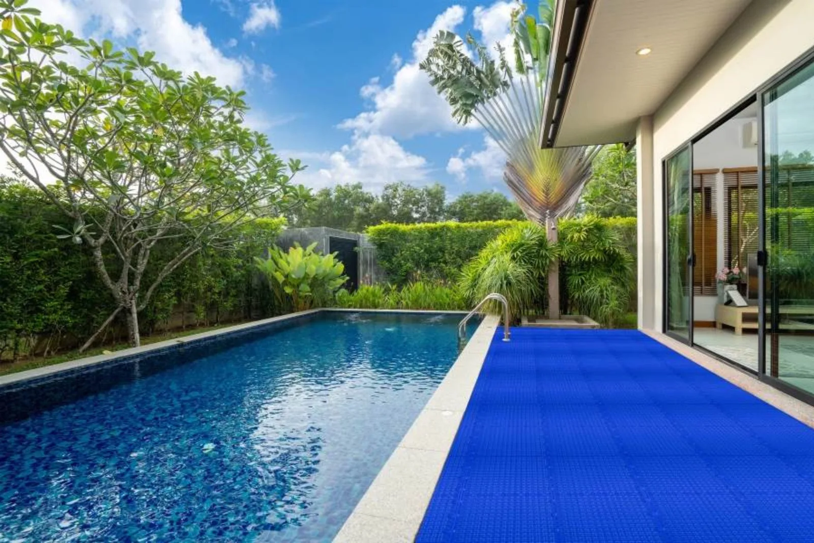 Backyard pool with blue drainage tiles on the pool deck