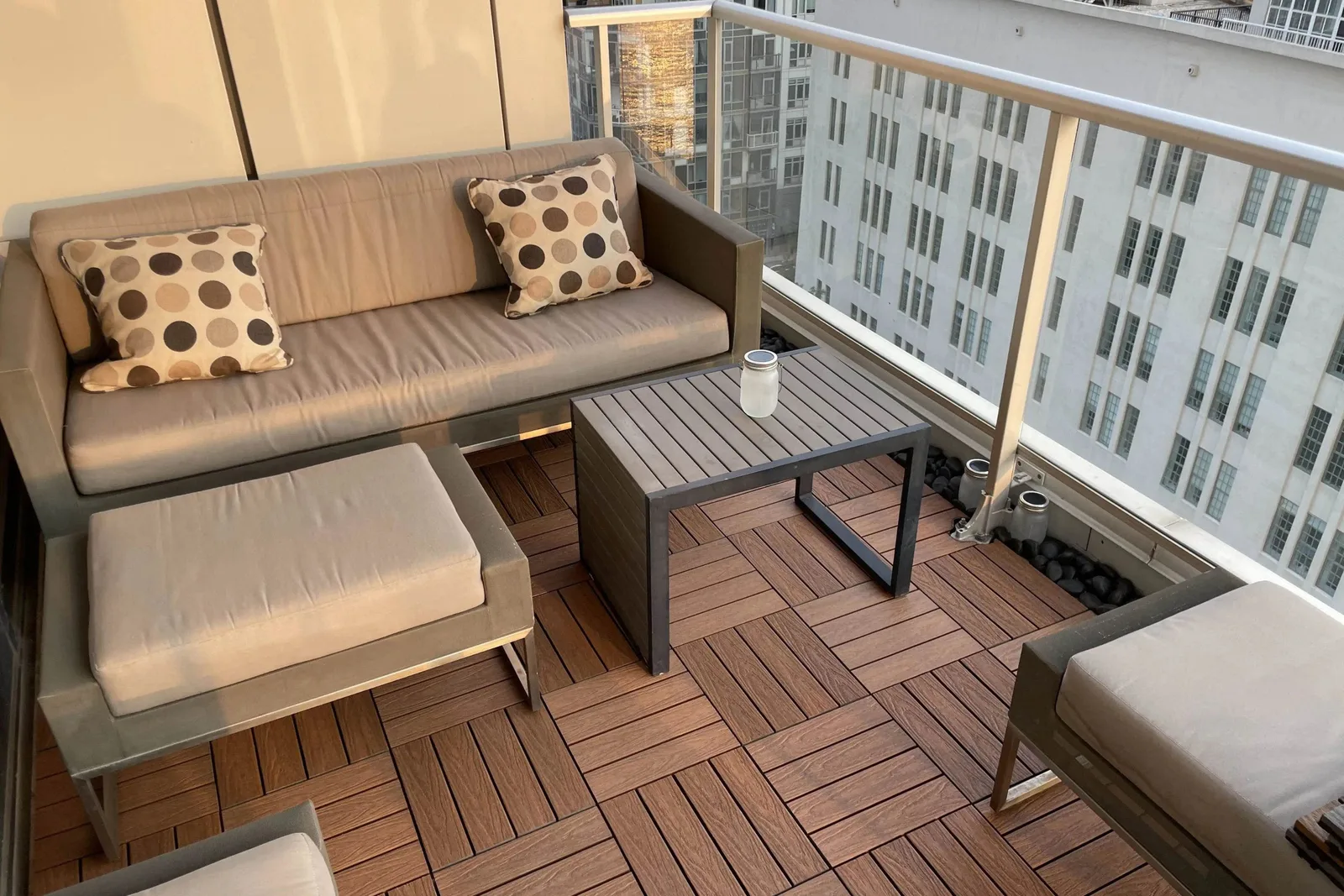 Composite deck tiles in a modern wood finish, creating a comfortable and professional-looking outdoor flooring solution on a high-rise balcony with outdoor furniture.