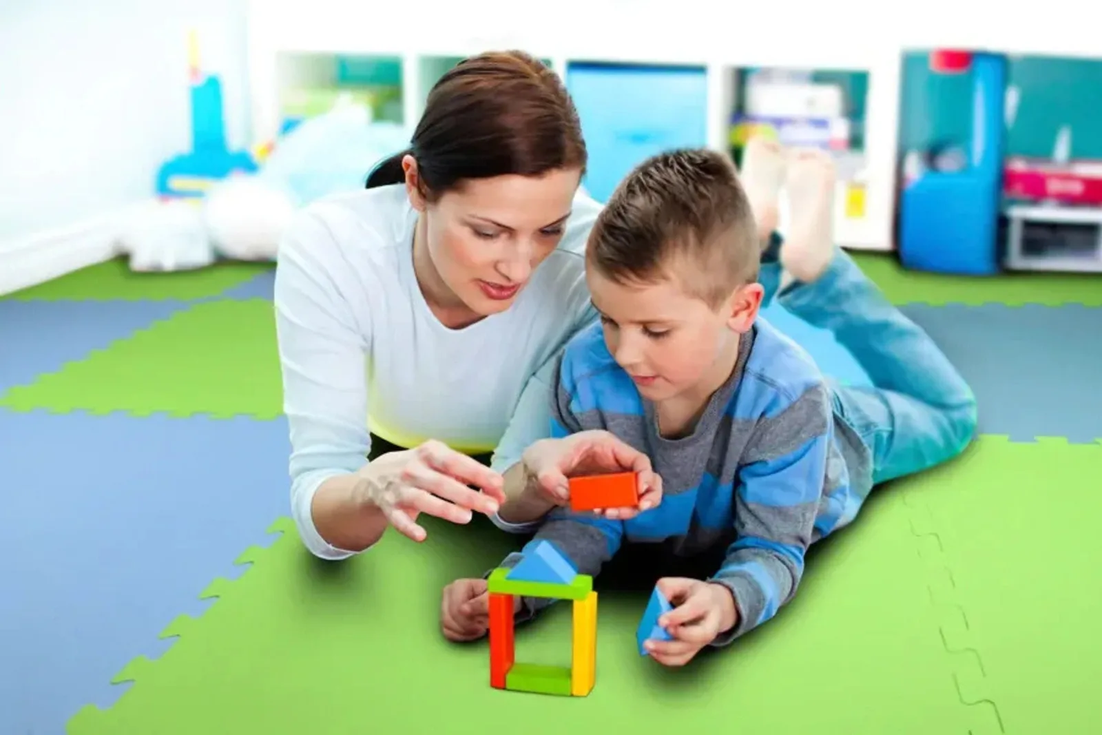 Soft Foam Flooring for Kids Soft interlocking foam mats in a children's playroom provide safe flooring for kids, featuring a mother and son playing on the multicolored foam tiles.