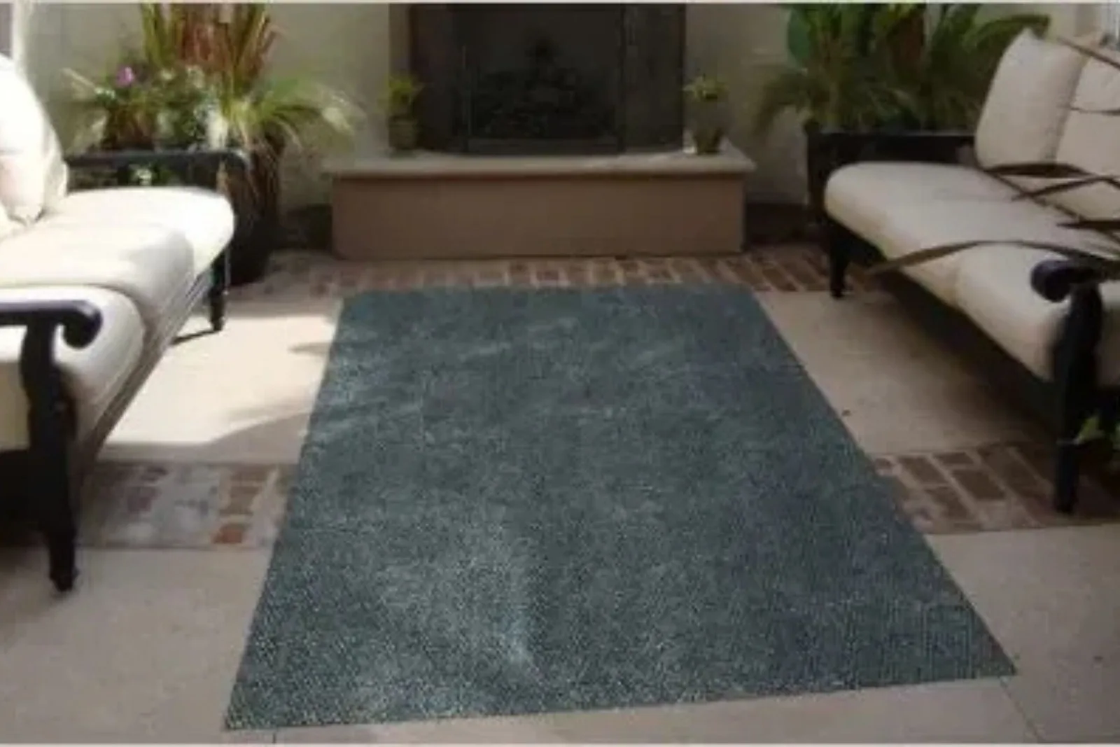 Outdoor patio with a durable textured charcoal gray area rug, a perfect and stylish, weather-resistant flooring solution.