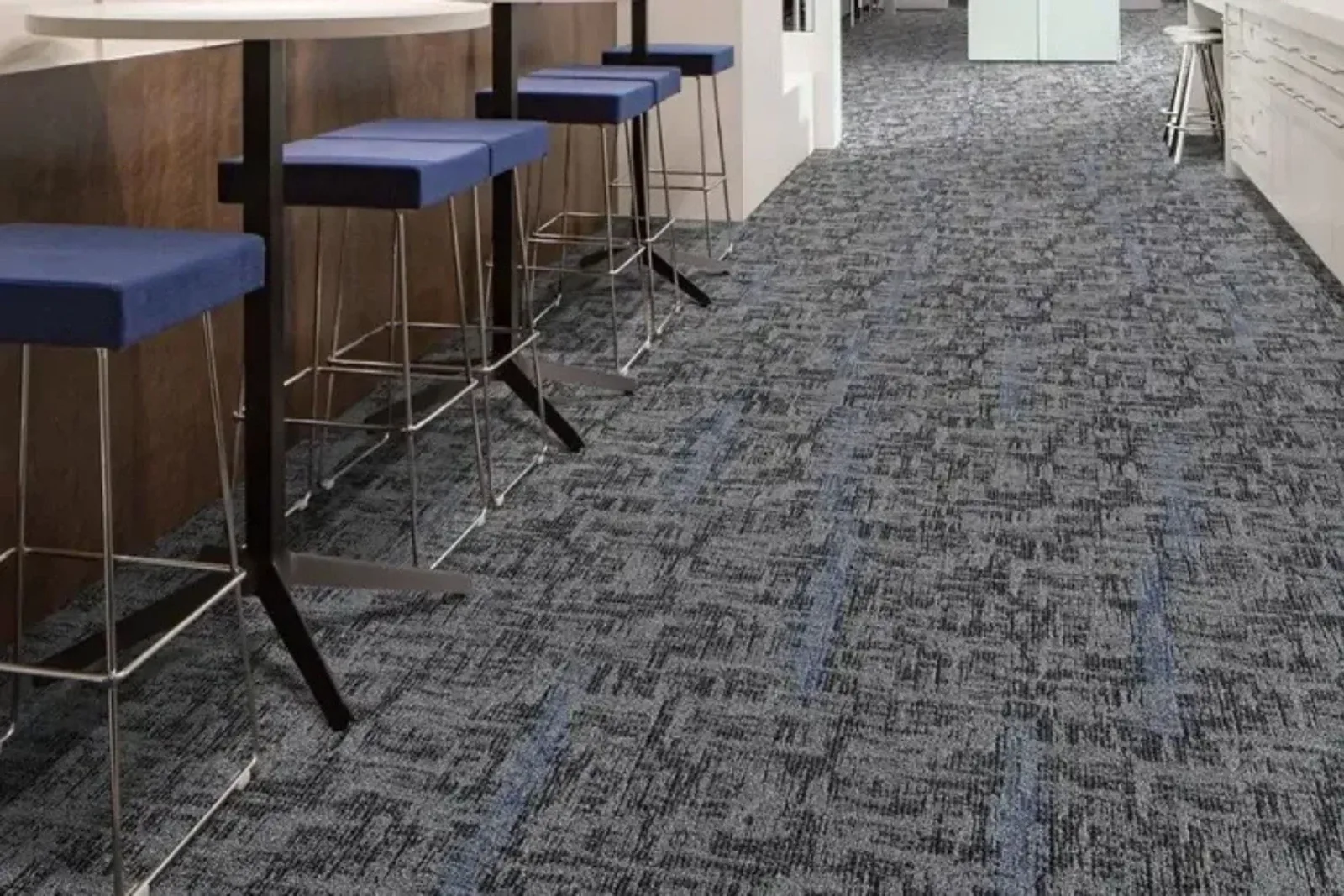 Modern office kitchen with a durable gray and blue patterned commercial carpet, a perfect and long-lasting flooring solution for high-traffic areas.
