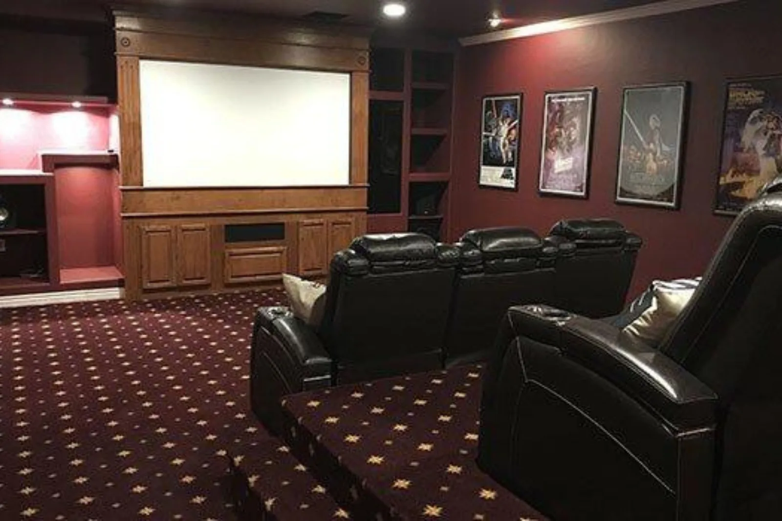Luxury home theater with a dark red patterned carpet, a plush and stylish flooring solution perfect for creating a cozy atmosphere.