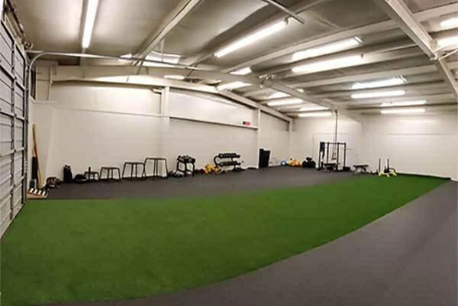 Gym turf provides a durable and low-impact artificial grass flooring solution for an indoor athletic training facility, with a dedicated area for sled pulls and other exercises.