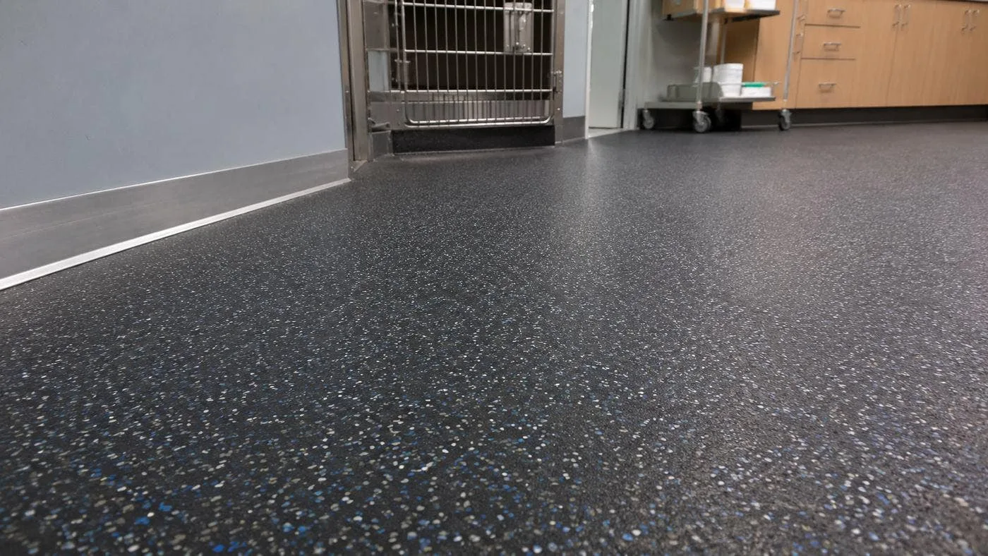 Rubber flooring installed in a veterinary treatment area with an edge strip along the wall