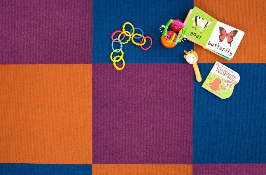 close up view of carpet tiles with children's toys in a playroom