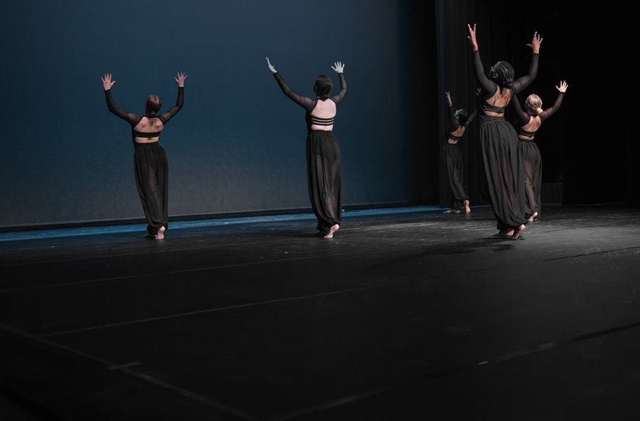 A dance team practicing on a stage