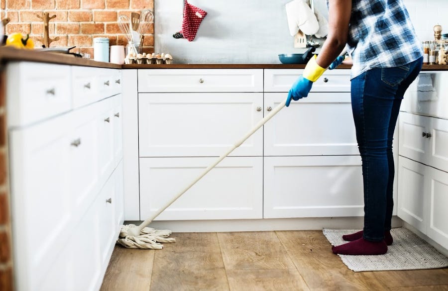Cleaing vinyl floors- Things to avoid: woman cleaning vinyl plank flooring