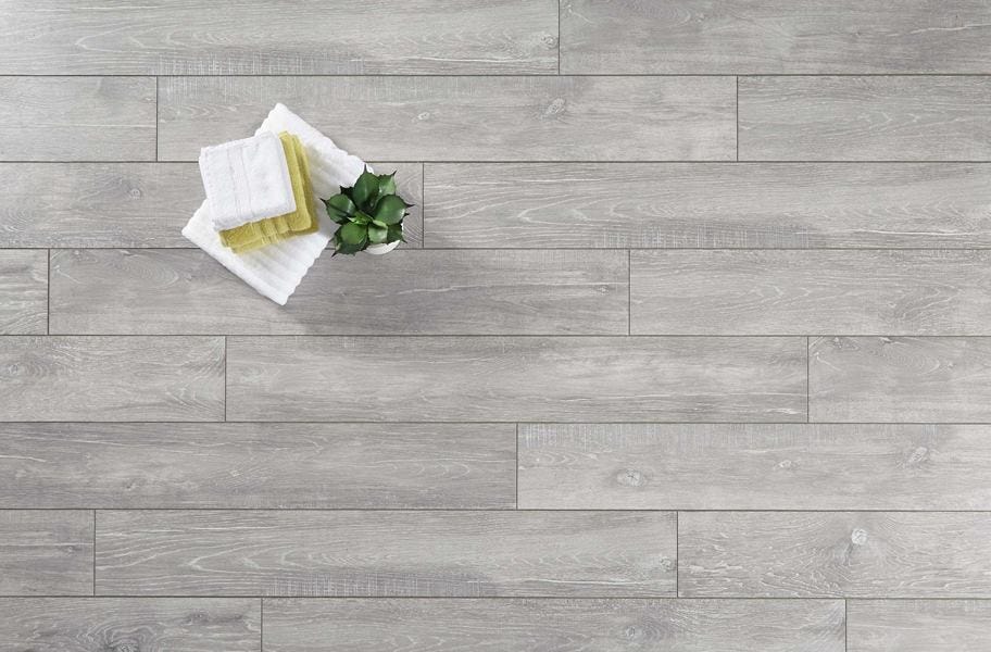 gray laminate flooring flat lay with hand towels, washcloths and plant. 