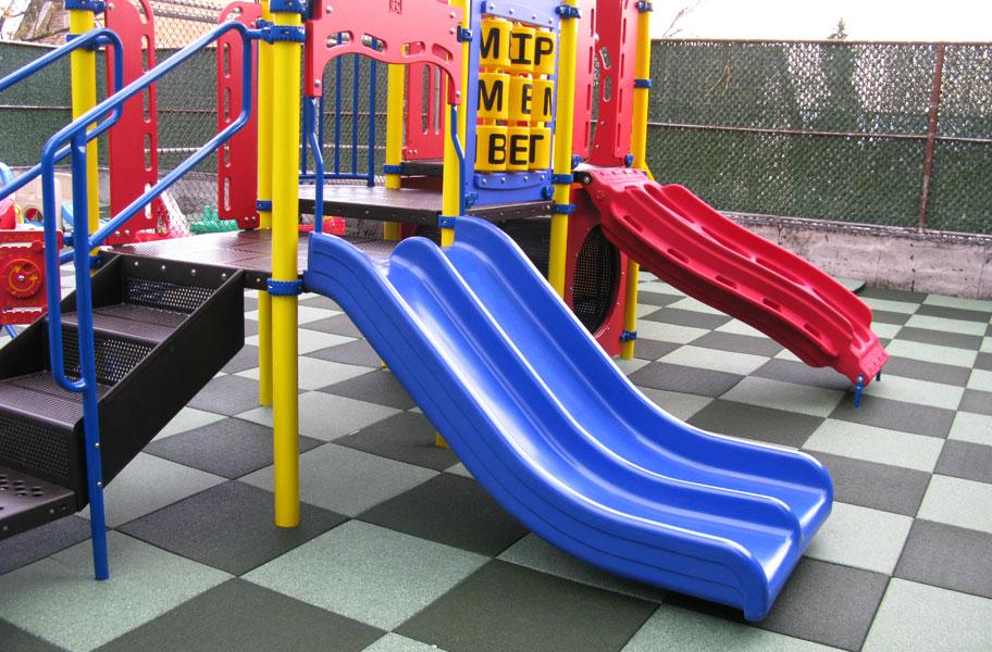 blue slide on checkered playground tiles