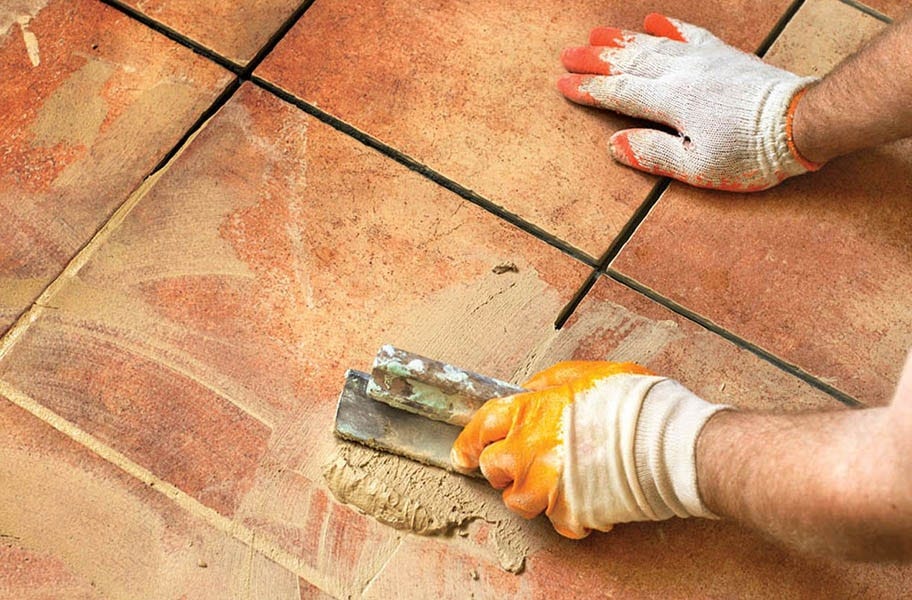 Applying grout with a sealing additive