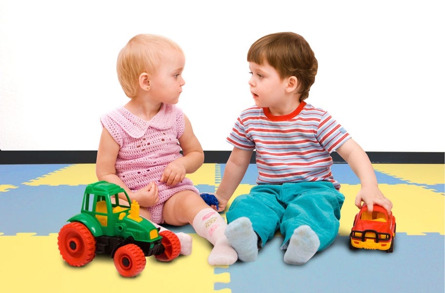 Babies playing on EVA foam floor tiles in a playroom setting