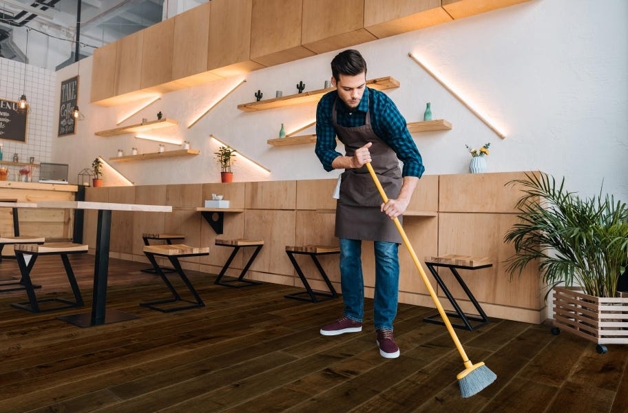 Sweep Regularly: Man sweeping Rio Grande Water Resist Oak Engineered Wood