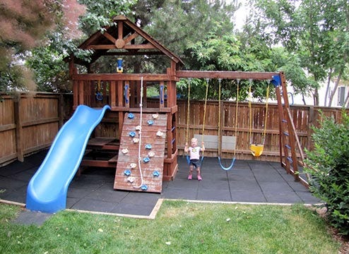 Playground in backyard with rubber flooring